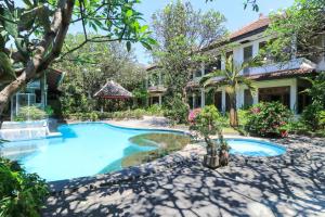 a house with a swimming pool in a yard at Sari Bali Resort in Kuta