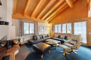 a living room with a couch and a tv at Apartments Kirchbühl in Grindelwald