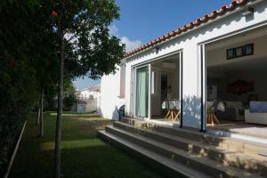 ein weißes Haus mit Glasschiebetüren und einem Hof in der Unterkunft SeaEsta in Les Deveses	