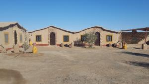 un edificio en un desierto con un patio de tierra en Secret du Sahara, en Merzouga