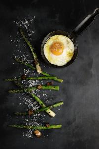 a frying pan with asparagus and an egg on a table at Malmaison Edinburgh City in Edinburgh