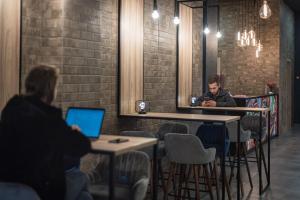 a man sitting at a bar with a laptop at Amarant Apart Hotel by CHM in Kyiv