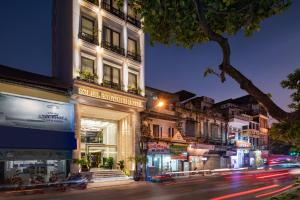 a city street at night with a building at Soleil Boutique Hotel Hanoi in Hanoi