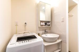 那霸的住宿－MrKINJO in Nicas Makishi，一间带洗衣机和水槽的浴室