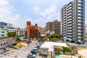 那霸的住宿－MrKINJO in Nicas Makishi，一座有高楼和有车的街道的城市