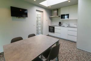 a kitchen with a table and chairs in a room at Barak de Vinck in Ypres +14 photos