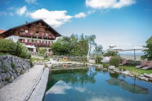 une maison avec un étang en face d'un bâtiment dans l'établissement Bussjägerhof, à Böbing