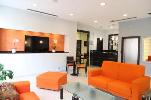 uma sala de estar com mobiliário laranja e uma televisão de ecrã plano em Albergo Cantiani em Ancona