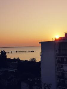 una puesta de sol sobre un cuerpo de agua con un muelle en Wolin-Travel Apartamenty Statek z widokiem na morze en Międzyzdroje