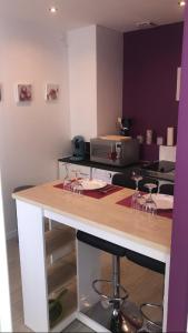 a kitchen with a counter with wine glasses on it at Studio confort N2 Valenciennes Wifi Netflix in Aulnoy