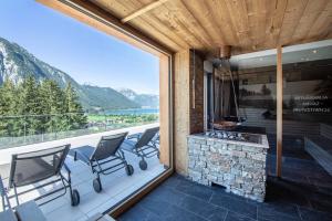 a patio with a fireplace and chairs on a balcony at Naturhotel Alpenblick in Maurach
