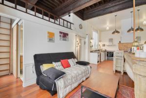 a living room with a couch and a kitchen at Le cocon des Deux Sirènes in Nancy