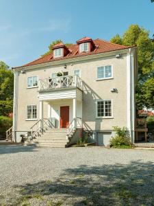 une grande maison blanche avec des escaliers et une terrasse couverte dans l'établissement Accommodation close to Stockholm City, à Stockholm