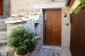 una puerta de una casa con una planta al lado en B&B La Perla nelle Dolomiti, en Castelmezzano