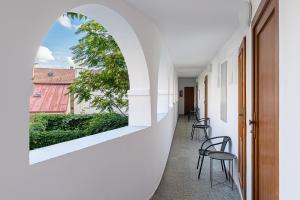 an arched window on the wall of a hallway with chairs at Penzion Maxwilliam in Znojmo