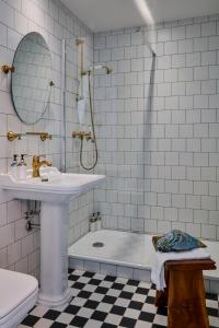 a bathroom with a sink, toilet, and bathtub at Max Brown Hotel Ku'damm in Berlin