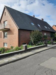 a brick house with a black roof on a street at Bei Bille und Jan in Bad Bentheim
