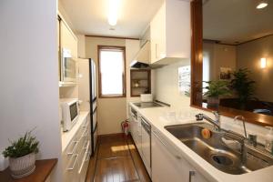 a kitchen with a sink and a refrigerator at Urayasu Guesthouse 浦安ゲストハウス in Urayasu +44 photos