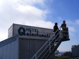 Dos personas de pie en una escalera junto a un cartel de hotel Cambridge en Hotel Quinchamali, en Chillán