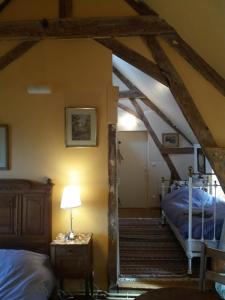 een zolderkamer met 2 bedden en een lamp bij La Berlandière in Le Merlerault