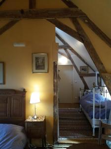 an attic room with two beds and a lamp at La Berlandière in Le Merlerault
