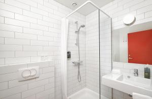 a bathroom with a shower, sink, and mirror at Hotel Edda Höfn in Höfn
