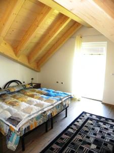 ein Bett in einem Zimmer mit Holzdecke in der Unterkunft Casa De Val in Calceranica al Lago