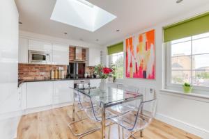 a kitchen with a glass table and chairs at Central Bright 3 Bed Flat with Parking in Edinburgh +30 photos
