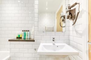 a white bathroom with a sink and a mirror at Central Bright 3 Bed Flat with Parking in Edinburgh