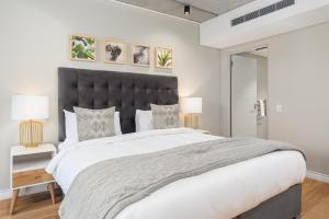 ein Schlafzimmer mit einem großen Bett mit schwarzem Kopfteil in der Unterkunft The Docklands Luxury Apartments in Kapstadt