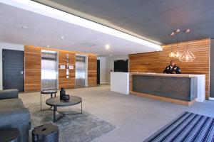 a man standing at a counter in a lobby at Luxury Docklands Apartments by ITC Hospitality in Cape Town +23 photos