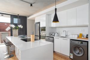 eine weiße Küche mit Spüle und Geschirrspüler in der Unterkunft The Docklands Luxury Apartments in Kapstadt + 261 Fotos
