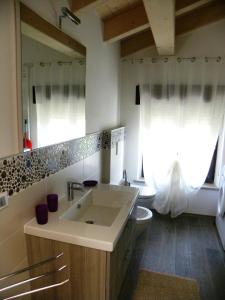 ein Badezimmer mit Waschbecken, Toilette und Spiegel in der Unterkunft Casa De Val in Calceranica al Lago + 84 Fotos