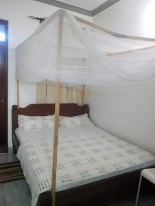 1 cama con dosel en una habitación en ANNA APARTMENTS MTWAPA, en Mtwapa