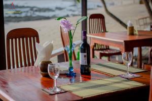 a table with a bottle of wine and glasses on it at Memento Resort in Ngapali