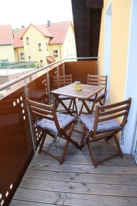 uma mesa de madeira e cadeiras numa varanda em Ferienwohnung Memmel em Sulzfeld