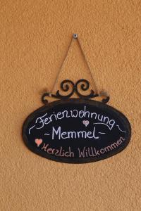 un signo colgado en una pared con un signo para amemormormormormormormormormorynamed en Ferienwohnung Memmel, en Sulzfeld