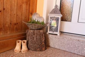 um alpendre com uma cesta e sapatos ao lado de uma porta em Ferienwohnung Memmel em Sulzfeld