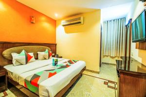 um quarto com uma cama num quarto em FabExpress Jaggi Palace Karol Bagh em Nova Deli