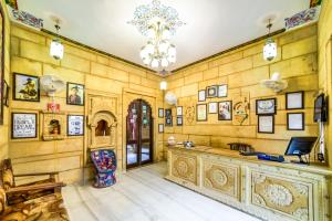 a living room filled with furniture and paintings at Hotel Heritage House in Jaisalmer