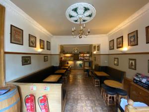 a restaurant with tables and chairs and a chandelier at Auld Mill House Hotel in Dunfermline +30 photos