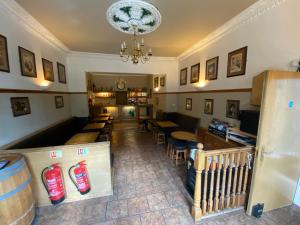 a restaurant with tables and chairs and a chandelier at Auld Mill House Hotel in Dunfermline