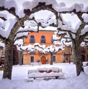 un banco cubierto de nieve frente a un edificio en Camino Condal en Oña