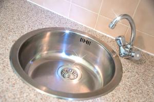 a stainless steel sink with a faucet in a counter at Ferienwohnung Rodenhof in Saarbrücken +17 photos