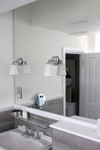 La salle de bains est pourvue d'un miroir et d'un lavabo. dans l'établissement The Hayden Pub & Rooms, à Londres