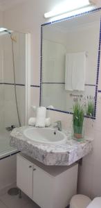 y baño con lavabo blanco y espejo. en Luz Azul, en Costa Calma