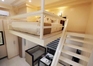 Zimmer mit 2 Etagenbetten und einer Treppe in der Unterkunft Rosetta Guest House in Ormoc City