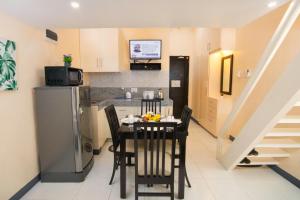a kitchen with a table with chairs and a refrigerator at Rosetta Guest House in Ormoc