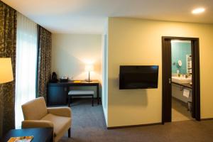A television and/or entertainment centre at Heide Spa Hotel & Resort