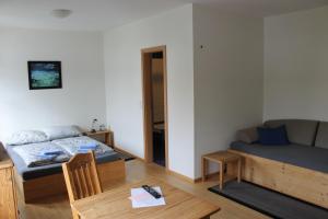 Landhotel Schnier في بريلون: غرفة بسرير واريكة وطاولة